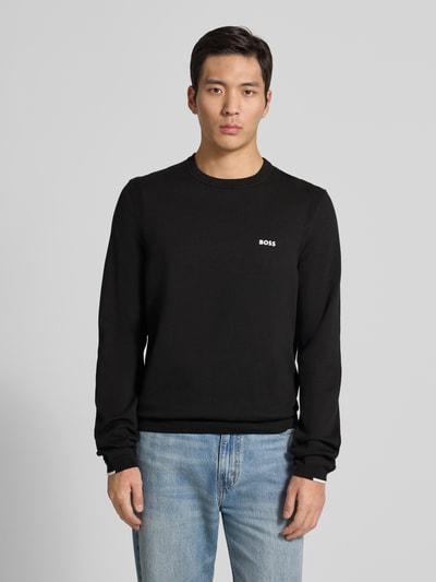 Männermodel trägt Regular Fit Strickpullover aus reiner Baumwolle Modell 'EVER-X' von BOSS Green, Optik: Unifarben, Label-Stitching, Rundhals, Langarm, gerippte Abschlüsse, Materialverarbeitung: Strick, Ganzkörperansicht von vorne.