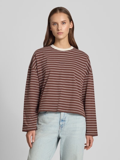 Vrouwenmodel draagt Longsleeve met Label-Stickerei van OH APRIL in bruin met witte strepen, pure katoen, losse pasvorm, ronde hals, geborduurd label, ruglengte bij maat S 53 cm, voorkant volledige lichaamsopname.