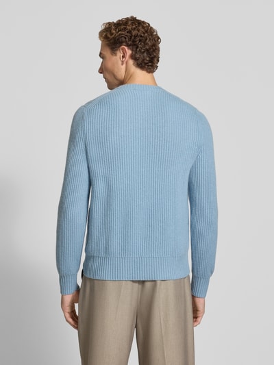 Männermodel trägt Strickpullover aus Kaschmir mit Rundhalsausschnitt von FTC Cashmere in Hellblau, Grobstrick, Ganzkörperansicht Rückansicht. Rückenlänge 68 cm, Ärmellänge 72 cm, gerader Schnitt, gerippter Rundhalsausschnitt.