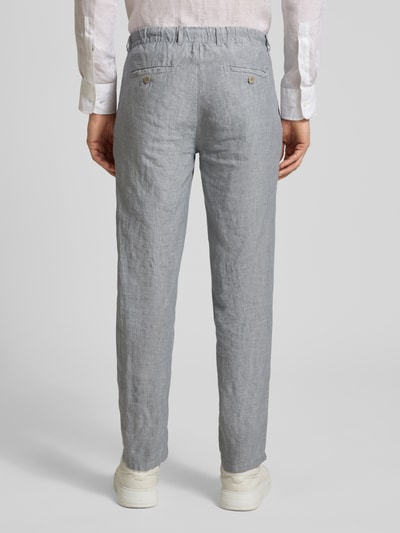 Männermodel trägt Slim Fit Leinenhose aus reinem Leinen Modell 'Fabio' von Brax in Hellgrau, Details wie Gesäßtaschen und Tunnelzug, Ganzkörperansicht Rückansicht.