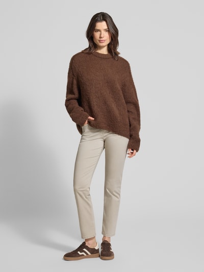 Modelka nosi Relaxed Fit Stoffhose mit elastischem Bund Modell 'Pamina' od Raphaela By Brax, beżowy bawełniany materiał, wygodny elastyczny pas, kieszenie z przodu i z tyłu, Szerokość w rozmiarze 36K: 35 cm, długość nogawki wewnętrznej: 73 cm, widok całej sylwetki z przodu.