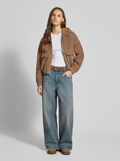 Modelka nosi Oversized Bomberjacke aus Baumwoll-Mix Modell 'KENZIE' od ONLY, beżowy sztruks, kieszenie z przodu, długi rękaw, cała sylwetka z przodu.