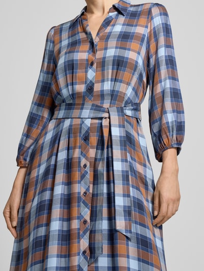 Vrouwenmodel draagt Midikleid uit zuiver viscose met platte kraag van MORE, getailleerde pasvorm, knoopsluiting, 3/4-mouw, elastische mouwboorden, tailleband, ruitpatroon in blauw, bruin en wit, zichtbare stofstructuur, ruglengte maat 36: 112 cm, borstwijdte maat 36: 34 cm, mouwlengte maat 36: 51 cm, Nahaufnahme bovenlichaam.