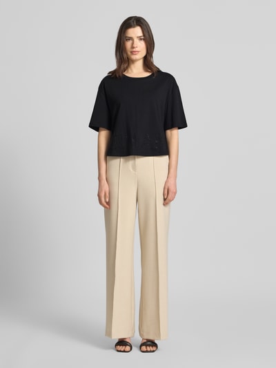 Frauenmodel trägt Boxy Fit T-Shirt mit Ziersteinbesatz von ARMANI EXCHANGE in Schwarz, reine Baumwolle, Rundhalsausschnitt, Ganzkörperansicht von vorne.