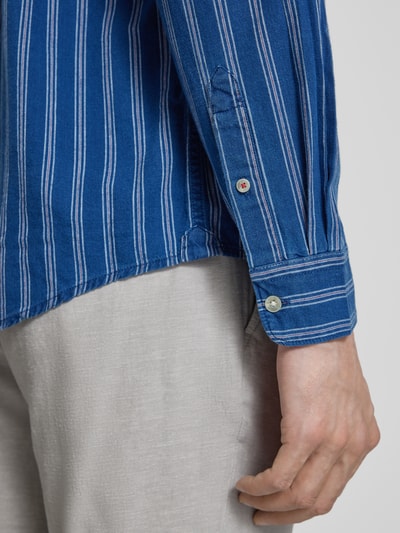 Männermodel trägt Regular Fit Jeanshemd aus pure katoen model 'PAXTON' van Pepe Jeans, blauw gestreept denim met sportmanchet, detailaufnahme rechter mouw.