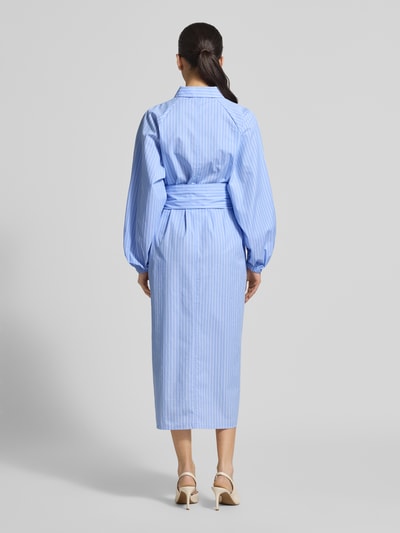 Vrouwenmodel draagt Regular Fit maxi-jurk met bloemenprint van Fynch-Hatton, puur katoen, met lange mouwen, getailleerd, overhemdkraag, blauwe tinten, elastische mouwboorden, doorknoopsluiting, afneembare stoffen band, ruglengte maat 36: 126 cm, borstwijdte: 57 cm, mouwlengte: 53 cm. Volledige lichaamsopname achterkant.
