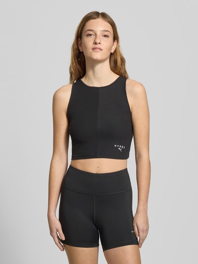 Frauenmodel trägt schwarzes PUMA x HYROX - Crop Top mit Label-Stitching, Baumwoll-Mix mit Stretch, Slim Fit, Rundhalsausschnitt, Ganzkörperansicht von vorne.