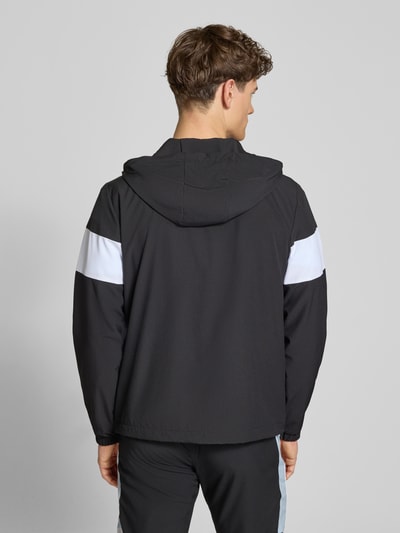 Mężczyznamodel nosi Regular Fit Jacke mit Logo-Stitching Modell 'Caspio' von SERGIO TACCHINI, czarny z białymi detalami, tkanina elastyczna, krój regular fit, kaptur ze ściągaczem, zamek, kieszenie, elastyczne mankiety, widok całej sylwetki od tyłu.