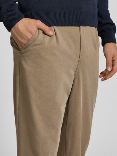 Mężczyzna nosi spodnie Regular Fit Bundfaltenhose mit Gesäßtaschen von REVIEW, beżowe, mieszanka materiałów z dodatkiem wiskozy, z zakładkami w pasie, kieszenią z tyłu, Szerokość w rozmiarze M: 46 cm, Długość wewnętrzna nogawki w rozmiarze M: 78 cm, zbliżenie na górną część spodni