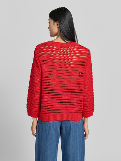 Vrouwenmodel draagt Oversized pullover in semi-transparant design Model 'Ajour' van monari, puur katoen, oversized fit, tricotlook, ruglengte maat 36: 54 cm, mouwlengte maat 36: 49 cm, geheel achteraanzicht.