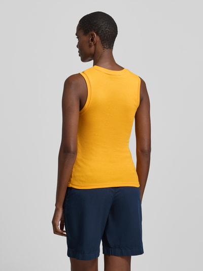 Frauenmodel trägt Slim Fit Tank Top aus reiner Baumwolle Modell 'SLIM CODY' von Tommy Hilfiger, Optik: Unifarben, Logo-Stitching, Rundhals, breite Träger, Material: reine Baumwolle, Ganzkörperansicht Rückansicht.