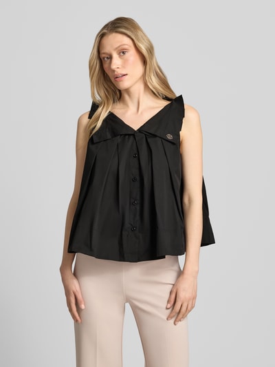 Frauenmodel trägt schwarze Bluse mit Umlegekragen und Rüschen von Rinascimento aus Baumwoll-Mix, Loose Fit, Nahaufnahme Oberkörper.