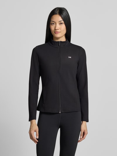 Frauenmodel trägt Slim Fit Trainingsjacke mit Logo-Print von Under Armour, schwarze glatte Oberfläche, Damen Trainingsjacke, Ganzkörperansicht von vorne.