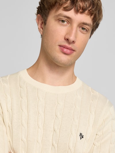 Männermodel trägt Slim Fit T-Shirt in Strick-Optik von REVIEW aus Reine Baumwolle, Logo-Stitching, Rundhalsausschnitt, Nahaufnahme Oberkörper.