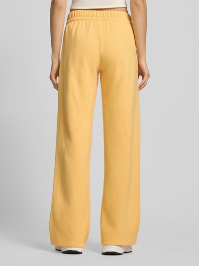 Frauenmodel trägt Sweatpants mit Logo und elastycznym bund von adidas Sportswear z mieszanki bawełny, krój regular fit, logo, tunel, długość wewnętrzna nogawki 79 cm, widok całej sylwetki z tyłu.