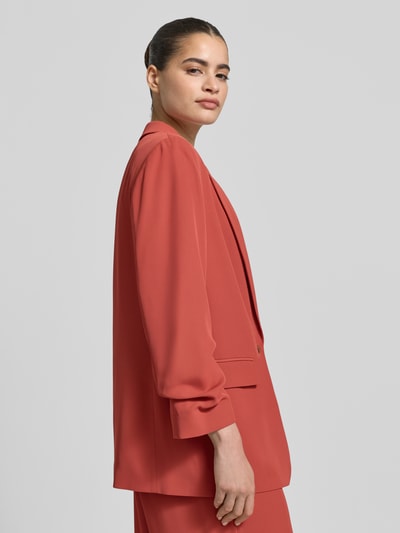 Frauenmodel trägt Oversized Blazer mit Raffungen von Jake*s Collection in Rot, Elastischer-Material-Mix, Oversized-Fit, Reverskragen, Knopfverschluss, Pattentaschen, Rückenlänge 70 cm, Brustweite 47 cm, Ärmellänge 50 cm; Nahaufnahme Oberkörper.