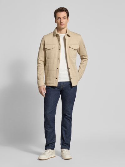 Männermodel trägt Regular Fit Sweatjacke aus Baumwoll-Mix von Tommy Hilfiger, unifarben, lange Ärmel, Brusttaschen, Ganzkörperansicht von vorne.