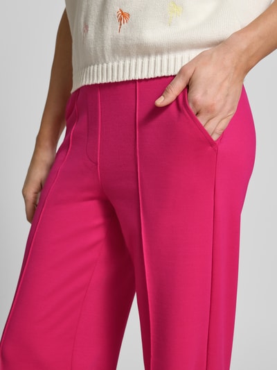 Frauenmodel trägt Flared Cut Hose mit elastischem Bund von Smith and Soul, leuchtend pink, Material-Mix mit Viskose-Anteil, Längsnähte, Nahaufnahme Oberkörper.