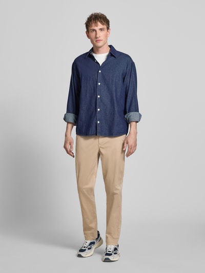 Męski model nosi Straight Fit Chino mit Eingrifftaschen Modell 'Vance' von Jack & Jones, mieszanka bawełny, krój straight fit, wpuszczane kieszenie, kieszenie z tyłu, zapięcie na guzik i zamek błyskawiczny, szerokość w rozmiarze 32/32: 43 cm, długość wewnętrzna nogawki: 67 cm, beżowy kolor, prosty fason; całopostaciowy widok z przodu.