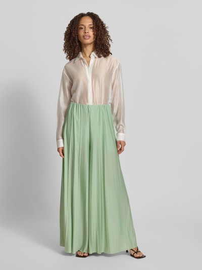Vrouwenmodel draagt stoffen broek van satijn met wide leg fit, elastische band en plissévouwen, model 'Samantha' van GUIDO MARIA KRETSCHMER WOMAN, bandwijdte maat 36: 34 cm, binnenbeenlengte maat 36: 73 cm, mintgroen met zachte glans, full body vooraanzicht.