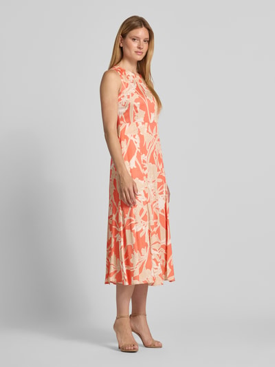 Frauenmodel trägt Midikleid aus Viskose mit Rundhalsausschnitt von Milano Italy im Allover-Look in Orange und Creme, A-Linie, Ganzkörperansicht von vorne.