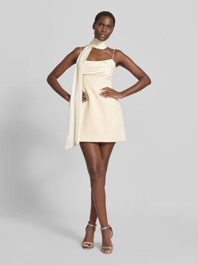 Frauenmodel trägt Cocktailkleid mit Schal Modell 'Darcy Scarf' von Forever New, cremefarbener Material-Mix, Spaghettiträger, tailliert, Ganzkörperansicht von vorne.