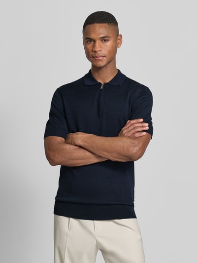 Männermodel trägt Slim Fit Poloshirt aus reiner Wolle von Matinique in Strick-Optik, dunkelblau, Polo-Kragen, Nahaufnahme Oberkörper. Herren Poloshirt, elastische Abschlüsse, Rückenlänge bei Größe M: 70 cm.