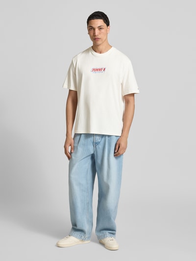 Männermodel trägt Regular Fit T-Shirt aus reiner Baumwolle von Tommy Jeans, Optik: Unifarben, Label-Schriftzug, Ganzkörperansicht von vorne.
