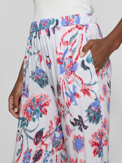 Frauenmodel trägt Culotte aus Viskose mit elastischem Bund von Christian Berg Woman, buntes Allover-Muster, Nahaufnahme Oberkörper.