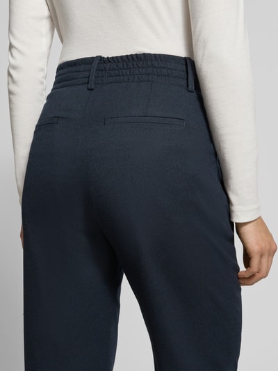 Frauenmodel trägt dunkelblaue Stoffhose mit Gesäßtaschen Modell 'DISPATCH' von Drykorn aus Material-Mix, Nahaufnahme Rückansicht.