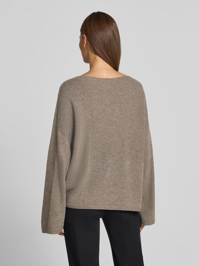 Frauenmodel trägt Oversized Pullover aus reiner Baumwolle in Strick-Optik von Emporio Armani, beige, lockerer Schnitt, Rückansicht, Ganzkörperansicht Rückansicht.