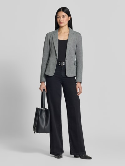 Vrouwenmodel draagt Slim Fit Kurzblazer met katoenmix model 'JULIA' van VERO MODA in lichtgrijs, gecombineerd met zwarte broek en tas, full-body frontale aanzicht