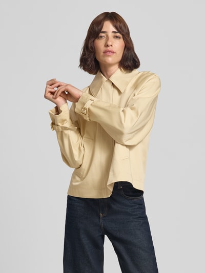 Frauenmodel trägt Regular Fit Trenchcoat aus reiner Baumwolle Modell 'Amotu-1' von HUGO, beigefarbene glatte Textur, Ganzkörperansicht von vorne, Damen Trenchcoat von HUGO.