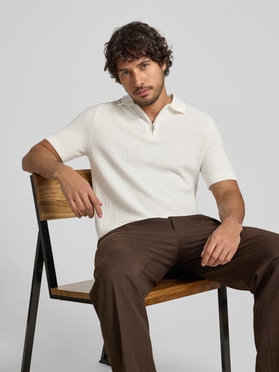 Męski model nosi Regular Fit Poloshirt aus reiner Bio-Baumwolle Modell 'CRAN' od SELECTED HOMME, biała struktura, krój regular fit, widok z przodu, zdjęcie w półzbliżeniu.
