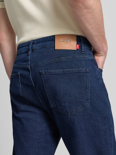 Männermodel trägt Straight Leg Jeans im 5-Pocket-Design Modell 'Ray' von JOOP! Jeans in Dunkelblau, Baumwoll-Mix, Nahaufnahme Rückansicht.