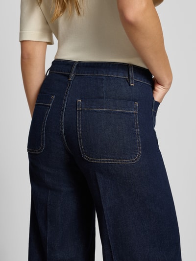Frauenmodel trägt Wide Fit Jeans aus Baumwoll-Mix Modell 'Jessie' von MANGO, dunkles Blau, aufgesetzte Taschen, Nahaufnahme Rückansicht.