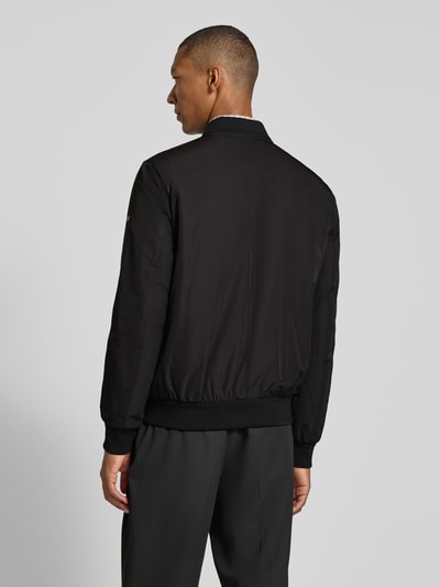 Männermodel trägt Regular Fit Jacke mit Stehkragen Modell 'Rapid' von CINQUE in Schwarz, elastische Abschlüsse, Rückenansicht, Ganzkörperansicht Rückansicht.