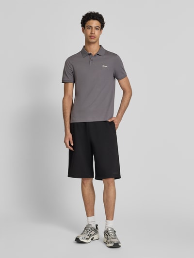 Männermodel trägt Slim Fit Poloshirt mit Label-Stitching von REVIEW in Grau aus Reine Baumwolle mit Knopfleiste, Ganzkörperansicht von vorne. Rückenlänge bei Größe M: 66 cm