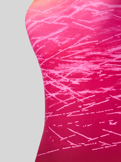 Frauenmodel trägt Badeanzug mit rückseitigen Cut Outs von LASCANA in Pink mit abstraktem Muster, Material-Mix mit Stretch-Anteil, Nahaufnahme Oberkörper.
