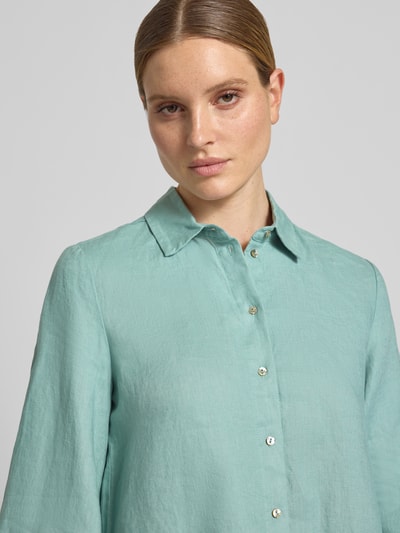 Frauenmodel trägt Relaxed Fit Leinenbluse mit 3/4-Arm von Christian Berg Woman in Mintgrün, Hemdblusenkragen, Knopfleiste, reine Leinenstruktur, Ganzkörperansicht von vorne. Rückenlänge 65 cm, Ärmellänge 48 cm, Größe 36.