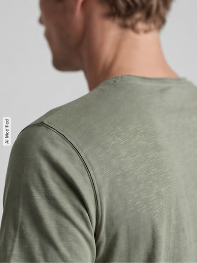 Männermodel trägt T-Shirt mit V-Ausschnitt von MCNEAL in olivgrün, weiche Textur, Regular Fit, Detailaufnahme Rückansicht