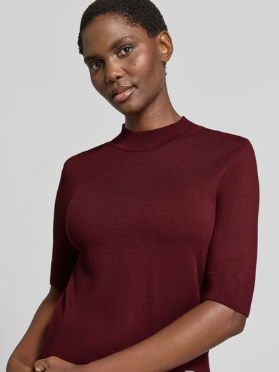 Vrouwenmodel draagt gebreid shirt uit viscosemix met stretch, recht model, ronde hals, 1/2-mouwen, labeldetail van MORE, Nahaufnahme Oberkörper. Ruglengte bij maat 36: 55 cm, mouwlengte bij maat 36: 29 cm.