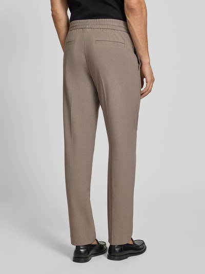 Männermodel trägt Relaxed Fit Sweatpants mit Viskose-Anteil von Lindbergh, Elastischer-Material-Mix, Bügelfalten, Bundweite 41 cm, Innenbeinlänge 79 cm, Produkt in Beige, Ganzkörperansicht Rückansicht.