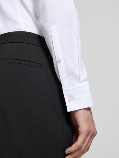 Männermodel trägt Slim Fit Freizeithemd aus reiner Baumwolle Modell 'KENNO' von HUGO in Weiß mit feinem Strukturmuster, Nahaufnahme Unterarm.