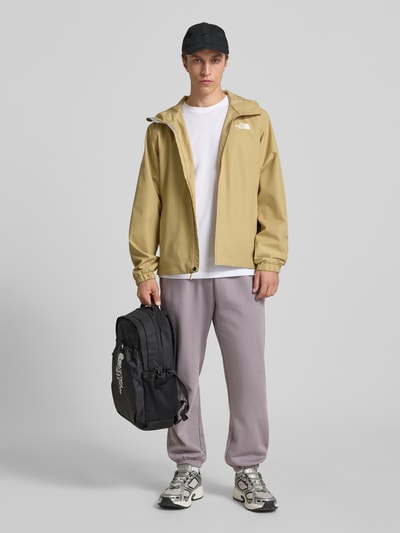 Männermodel trägt Sweatpants mit Logo-Stitching von The North Face, Baumwoll-Mix, relaxed fit, Hellgrau, elastischer Bund, Ganzkörperansicht von vorne.