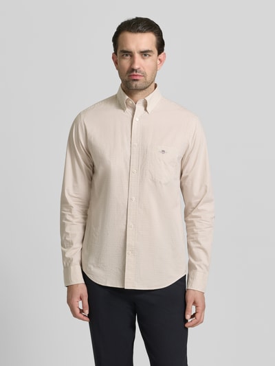 Męski model nosi Slim Fit Freizeithemd mit Logo-Stitching od Gant, bawełna, krój slim fit, kieszeń na piersi, widok całej sylwetki z przodu.