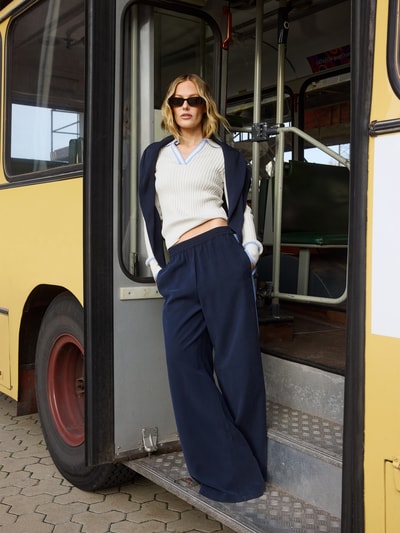 Frauenmodel trägt Fließende Viskose-Hose mit Kontraststreifen - curated by Tinvcb von SIC, weites Bein, elastischer Bund, dunkelblau, Gesäßtaschen, Bundweite 37 cm, Innenbeinlänge 80 cm, Ganzkörperansicht von vorne
