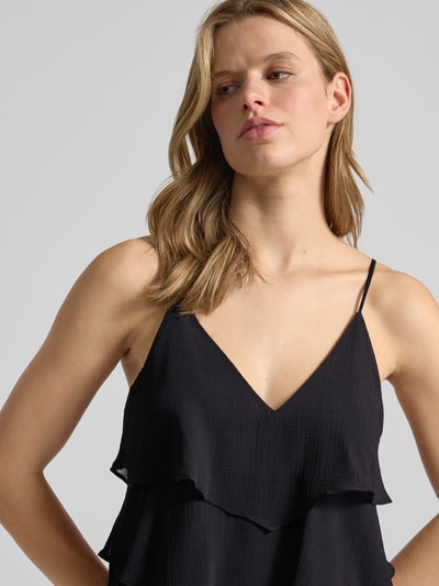 Frauenmodel trägt Regular Fit Trägertop mit Volants Modell 'LINN' von Only in schwarzer Unifarbe, V-Ausschnitt, Nahaufnahme Oberkörper