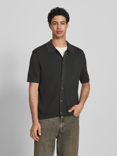 Męski model nosi Regular Fit Freizeithemd aus reiner Baumwolle od Marc O'Polo Denim, efekt: jednolity kolor, krój regular fit, naszywka z logo, kołnierzyk polo, dekolt w serek, listwa guzikowa, krótki rękaw, zakończenia prążkowane, wykończenie materiału: dzianina, 100% bawełna, kolor ciemny, tekstura prążkowana, przód, całe ciało.