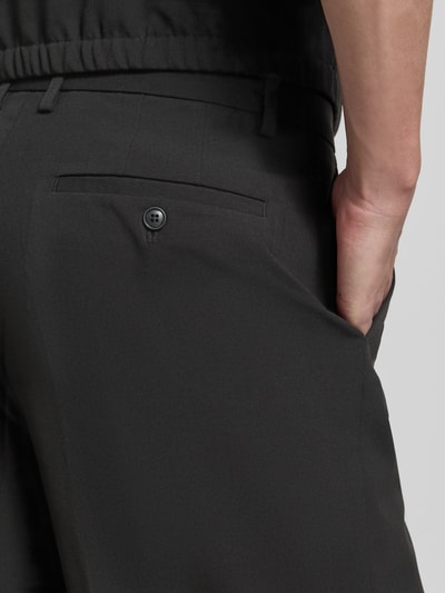 Männermodel trägt Straight Fit Shorts mit Viskose-Anteil von Lindbergh in Schwarz, Gesäßtasche, Bundfalten, Detailaufnahme Rückansicht. Elastischer-Material-Mix mit Viskose-Anteil, Haken-Reißverschluss, Bundweite 44 cm, Innenbeinlänge 30 cm, Größe M.